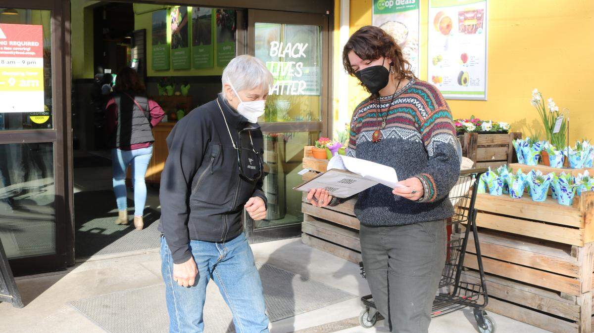 Carly Lloyd (right) spoke with Maple Falls resident Amy Mower outside the Community Food Co-op in Bellingham, Wash., on Wednesday, Jan. 26. Lloyd helped collect signatures for a petition opposing the Bessie timber sale, which contains century-old trees.
