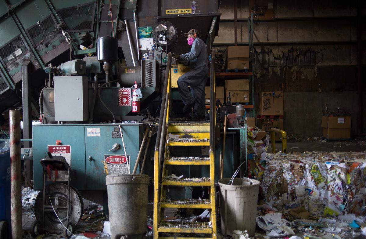 Flavio Pena uses a baler to press recycled paper into bales weighing about 1,300 pounds each at Northwest Recycling, Inc. in Bellingham.