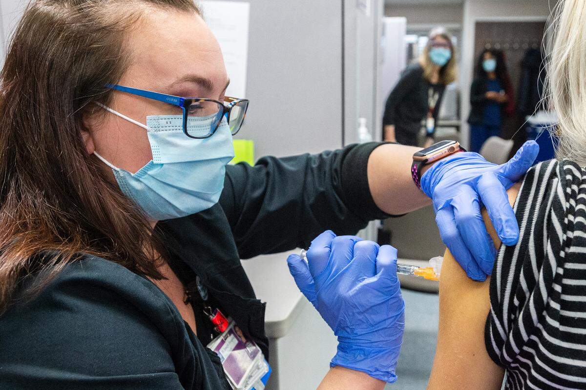 Nurse Leah Lyons administers the second shot of the Pfizer COVID-19 vaccine to Haley Canter of Bellingham on Saturday afternoon, Feb. 20, at PeaceHealth St. Joseph Medical Center in Bellingham. The vaccine clinic was held for hospital employees.