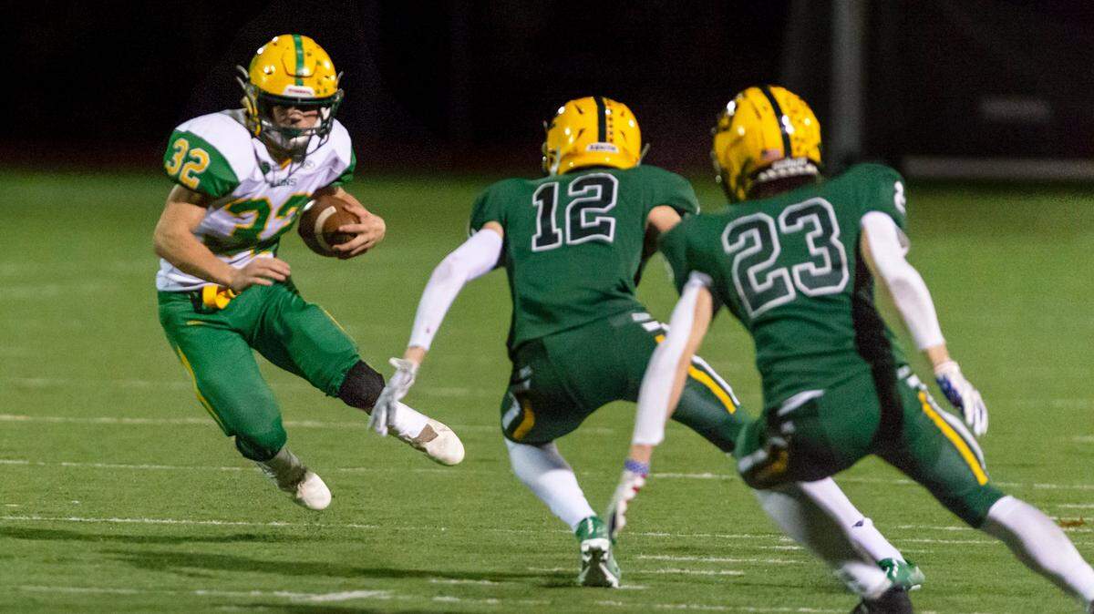 Lynden running back Lane Heeringa (32) attempts to evade Sehome defenders Braddock Duckworth (12) and Alden Jacobs (23) as he sweeps around the defensive line Oct. 15 at Civic Field in Bellingham. The Lynden Lions defeated the Sehome Mariners 23 to 7.
