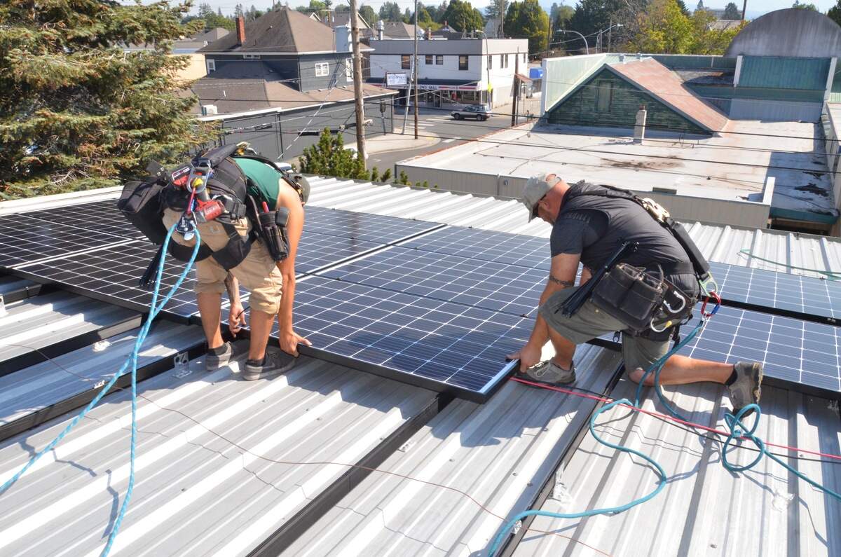 Workers from Ecotech Solar install solar panels to the roof of the RE Store in 2019. RE Sources recently recieved another grant from Puget Sound Energy to install more panels.