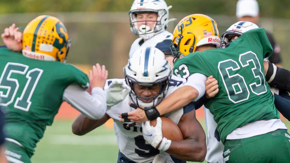 Sehome defenders KJ McDowell (51), left, and Grant Wei (63) stop Squalicum running back Djouvensky Schlenbaker (9) after a short gain during a 2021 game at Civic Stadium. Squalicum meets Sehome in a crucial 2022 season Week Eight Class 2A Northwest Conference showdown Friday, Oct. 21, at Civic Stadium, with a single remaining NWC state playoff spot on the line.