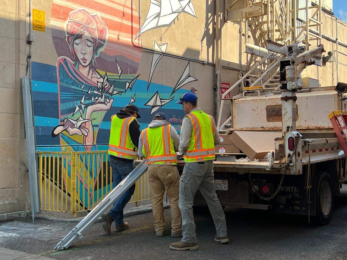 Public Works Department employees work to install a metal gate at the Holly Street entrance to an alley west of Railroad Avenue on Wednesday, April 29, 2026, in Bellingham, Wash.