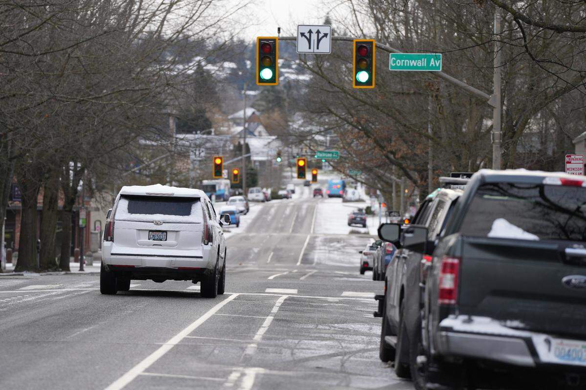 A snow-covered vehicle drives through downtown Bellingham, Wash., on February 3, 2025.