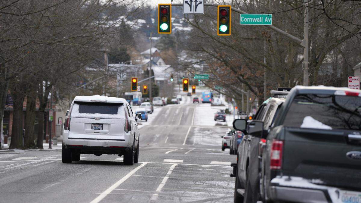 A snow-covered vehicle drives through downtown Bellingham on Monday.