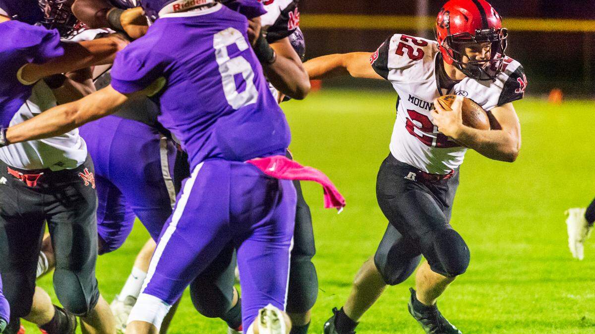 Mount Baker running back Jesse Sande (22) breaks the line of scrimmage to gain short yardage and make the first down during the third quarter on Friday evening Oct. 8, at Nooksack Valley High School in Everson. Mount Baker defeated Nooksack Valley 40 to 34.