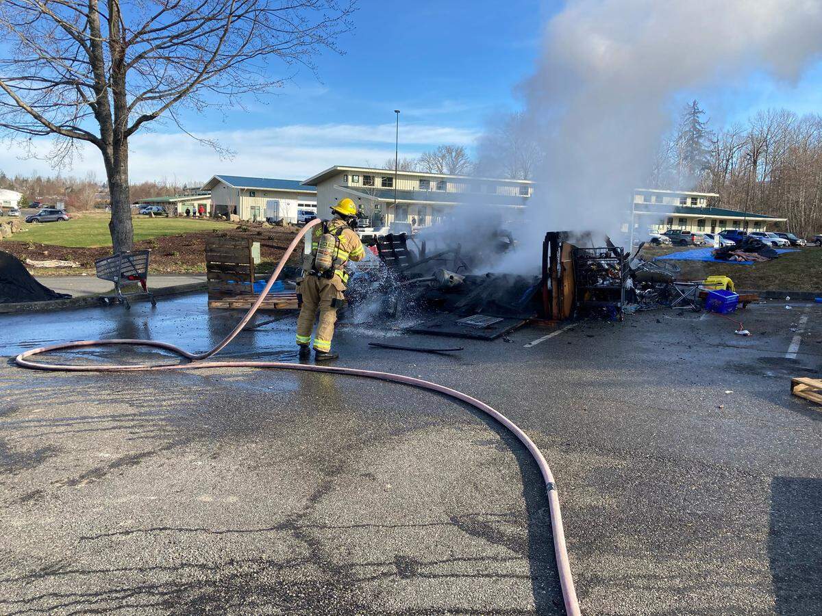 Bellingham Fire Department crews work Monday morning, March 8, to put out a fire at the homeless encampment in the lower parking lot of the Frank Geri Softball Fields in Bellingham. A propane heater explosion is believed to have caused the fire.