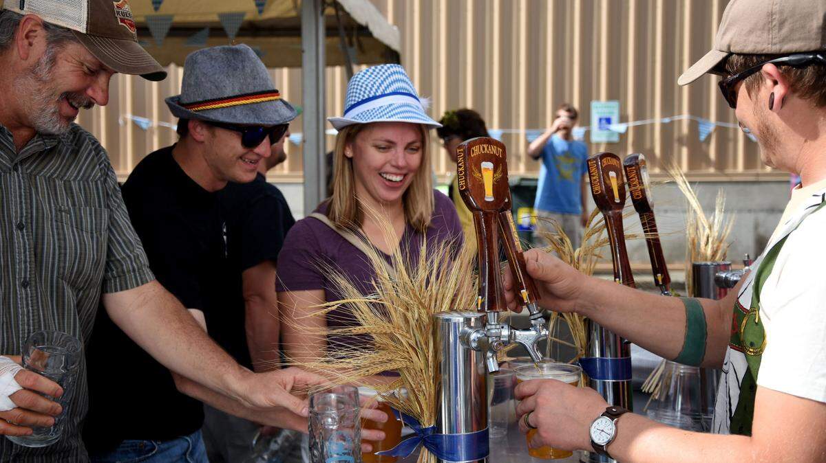 Bill Rink, Adam Hagen and Paige Hagen have their drinks refilled at the outdoor tap at Chuckanut Brewery in September 2016.