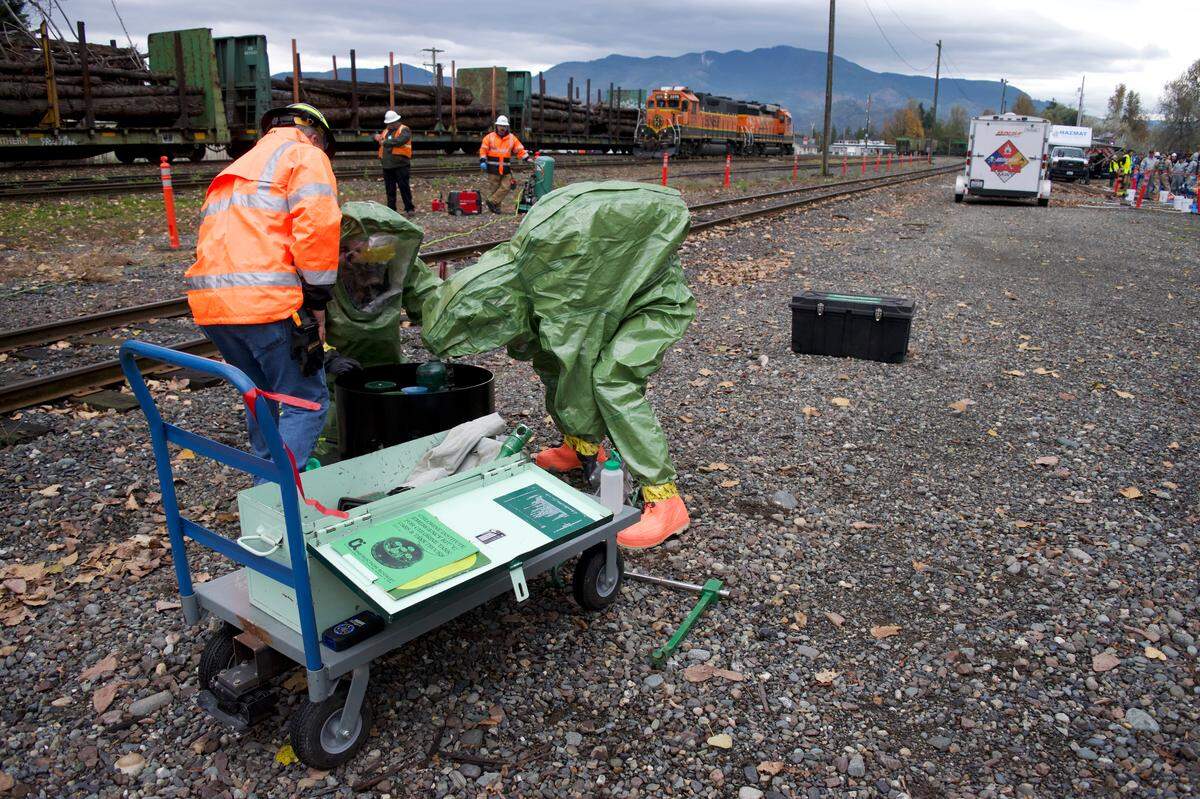 Firefighters dressed in hazardous material gear practice sealing a leaking valve during a train derailment simulation in Sumas on Oct. 16, 2019.
