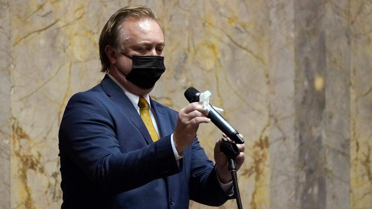 Sen. Doug Ericksen, R-Ferndale, wipes off a microphone before speaking on the Senate floor in January. There’s been no word on the location or condition of Washington state senator who was stricken with COVID-19 in El Salvador a month ago.