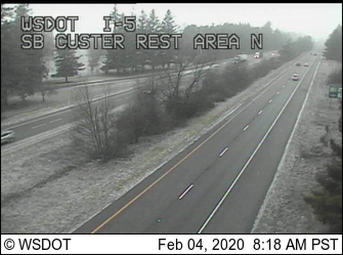 Washington State Department of Transportation traffic cameras show snow beginning to collect Tuesday morning along the side of Interstate 5 near the Custer rest stop in Whatcom County.