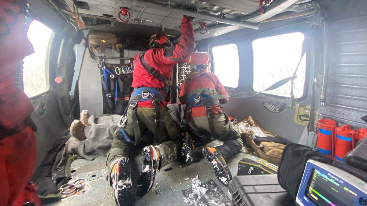 Naval Air Station Whidbey Island Search and Rescue crew members tend to an injured snowmobiler rescued Saturday, April 1, near Mount Baker.