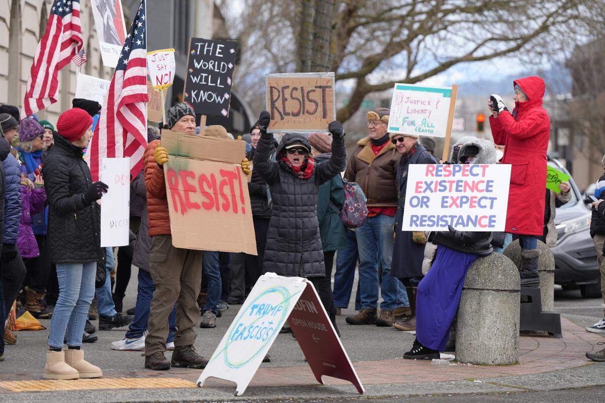 Participants display signs during Wednesday’s protest in Bellingham.