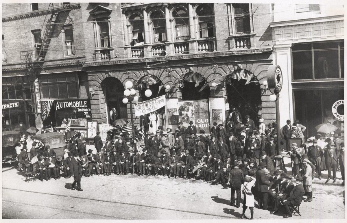 About 400 veterans at the 32nd encampment of the Civil War Veterans of Washington and Alaska are photographed in June 1914 in front of Beck’s Theater on Cornwall Avenue, later the site of the downtown J.C. Penney store. In 1915 a movie projection room was added and the theater was renamed the Metropolitan Theater.