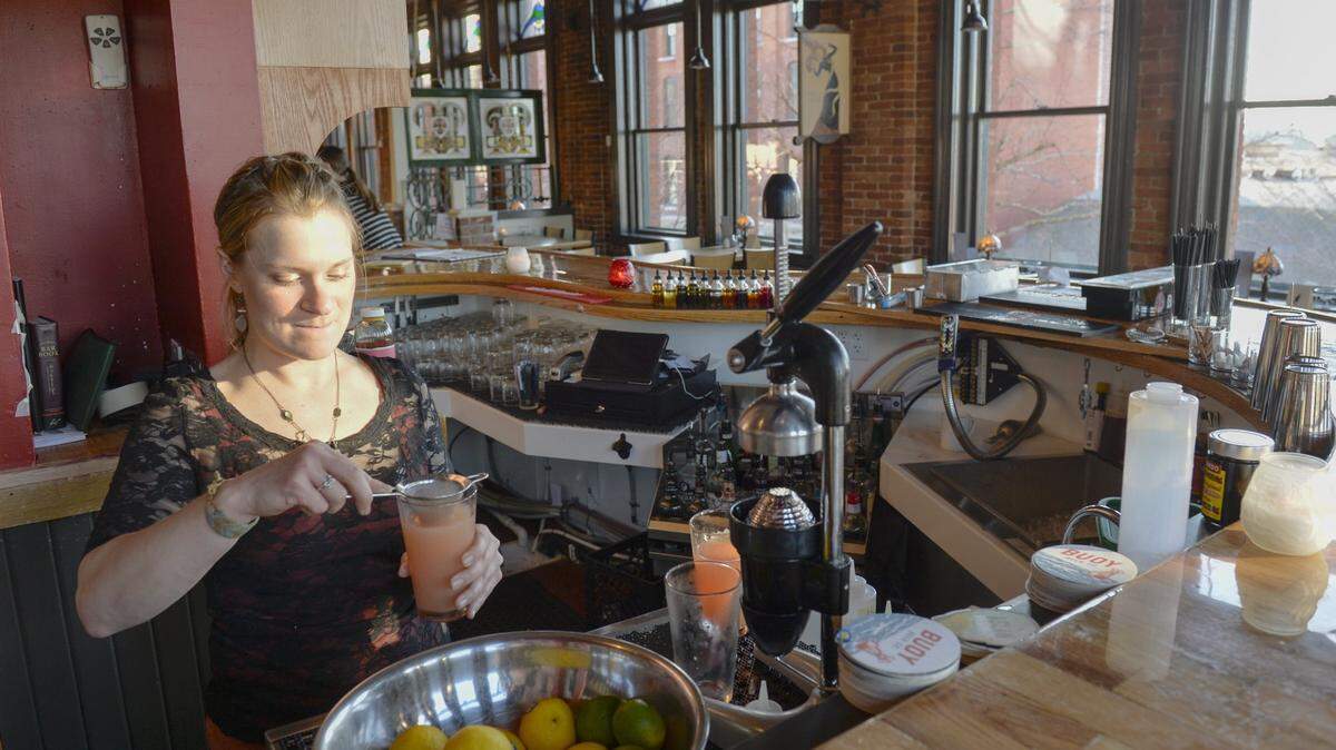 Bartender Kari Evans works behind the bar at the Black Cat restaurant in 2015. People have reportedly seen a phantom bartender inside, according to Whatcom County Community College paranormal phenomena instructor Matthew Thuney.