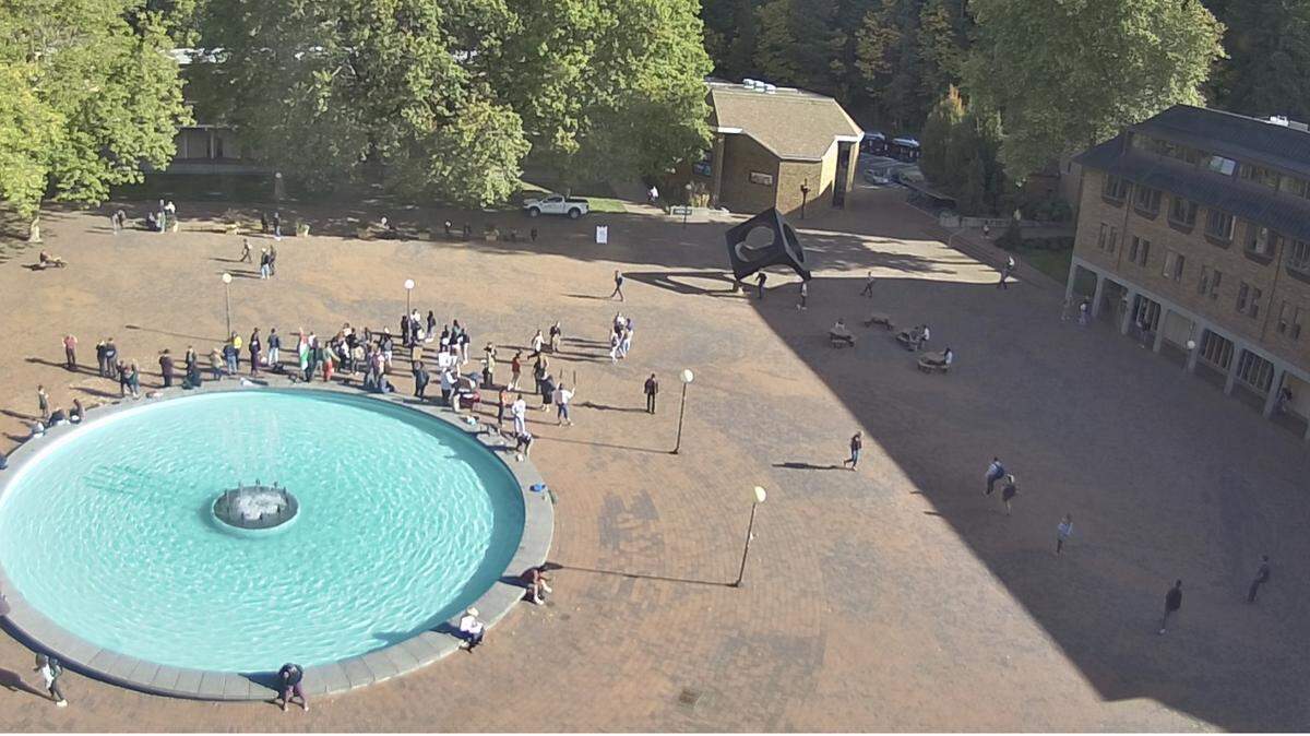 In a screenshot from a webcam Friday above Red Square at Western Washington University, about 30 people gather waving placards and the Palestinian flag at Fisher Fountain, where the Arab Student Association had planned a rally.