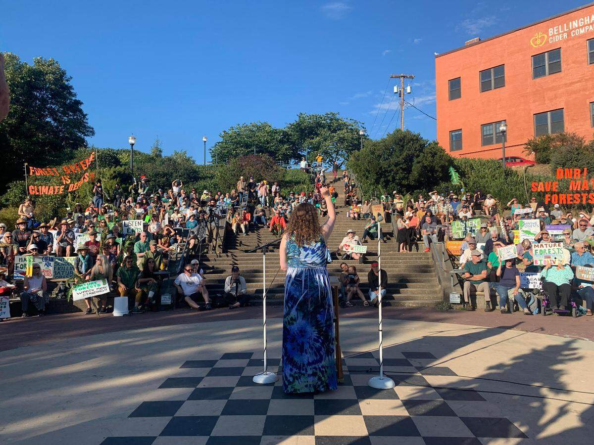 Whatcom County Council member Kaylee Galloway holds her fist up during a rally to protect mature forests in Washington in 2023 at the Maritime Heritage Park Amphitheater.