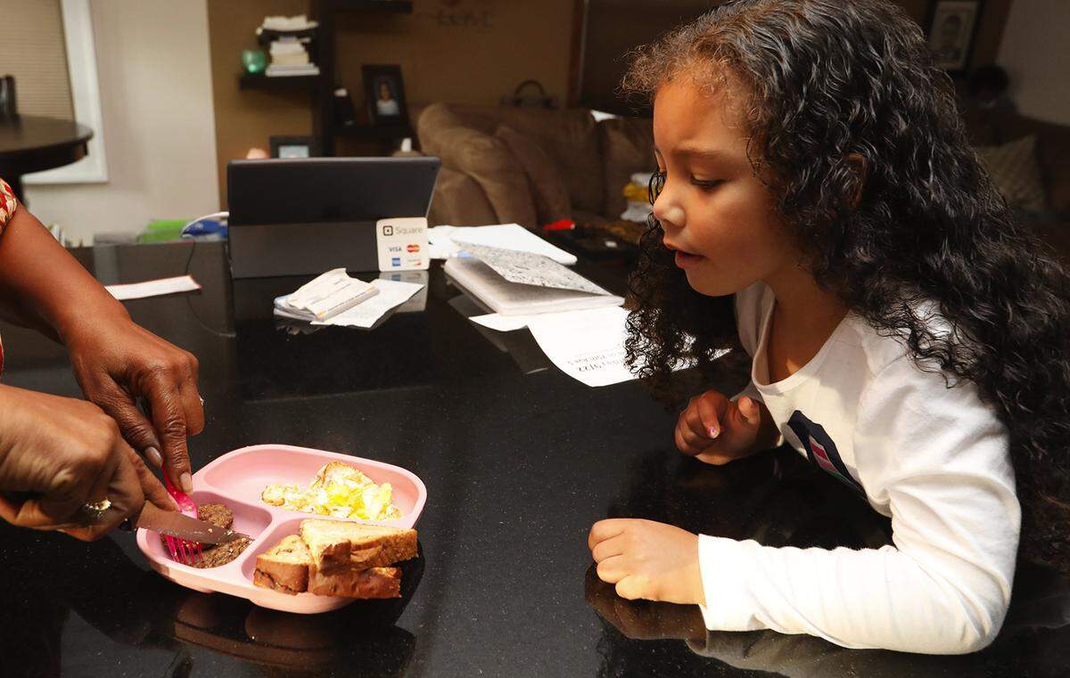 Alesia Cannady prepares breakfast for her 4-year-old granddaughter Aleiyah Cannady before taking her to preschool in September 2018 in Seattle. Alesia, 64, has raised Aleiyah almost from birth and doesn’t get benefits afforded to foster parents.