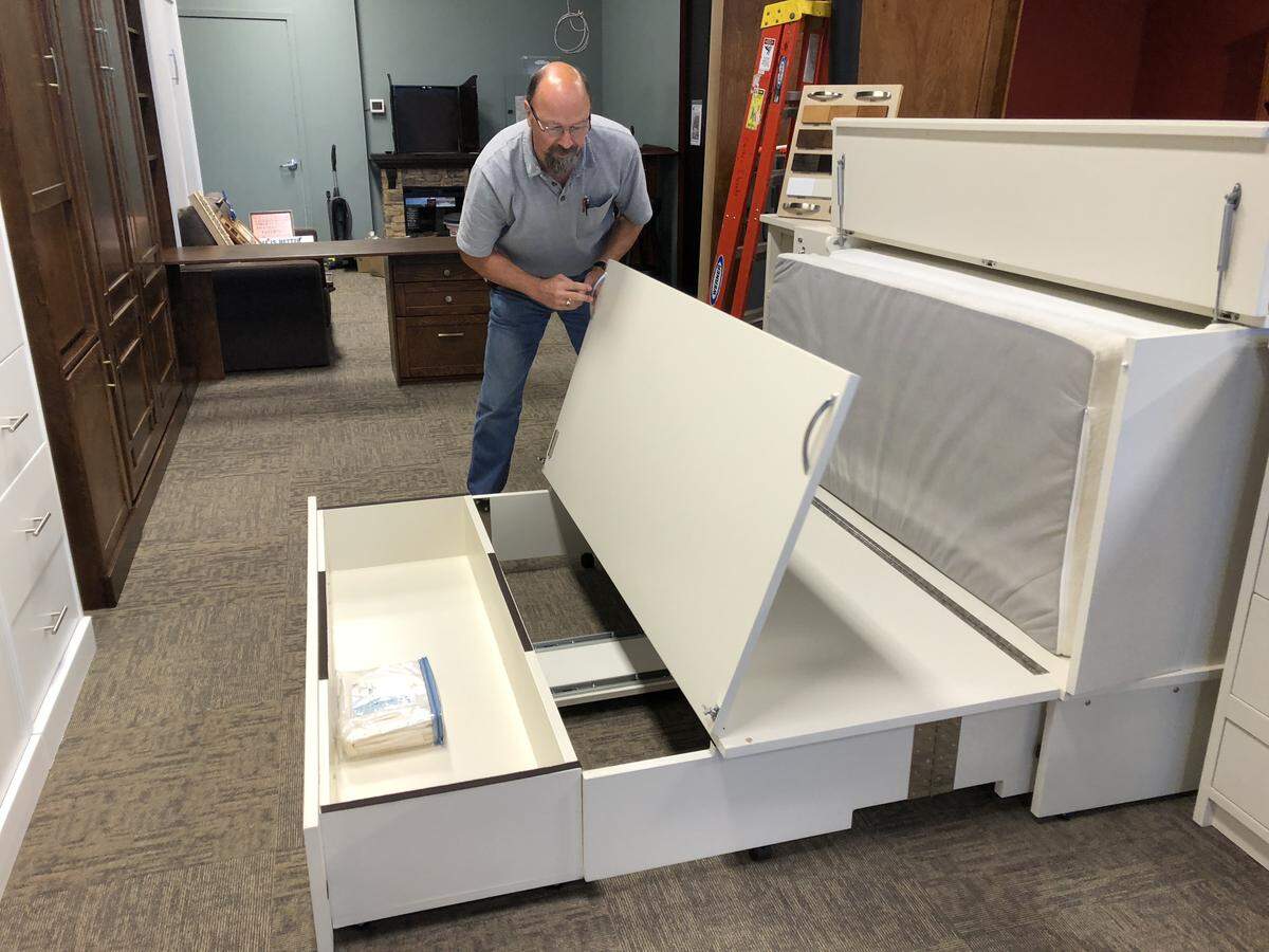 Mike Buchholz demonstrates converting a dresser into a bed. Buchholz is opening Spare Room Furniture and Wallbeds “n” More at 2420 James St., next to Trader Joe’s. The store will open on Sept. 17.