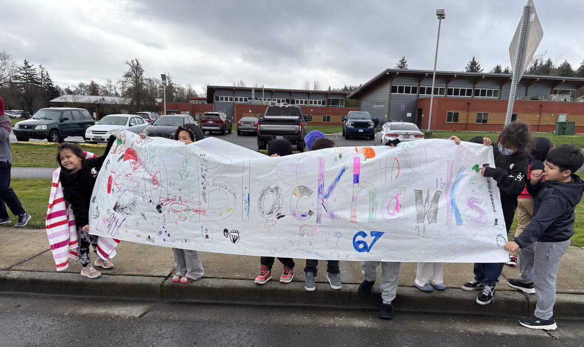 Students hold up a homemade banner honoring the Lummi Nation School Blackhawks basketball teams during a parade Friday in Bellingham.