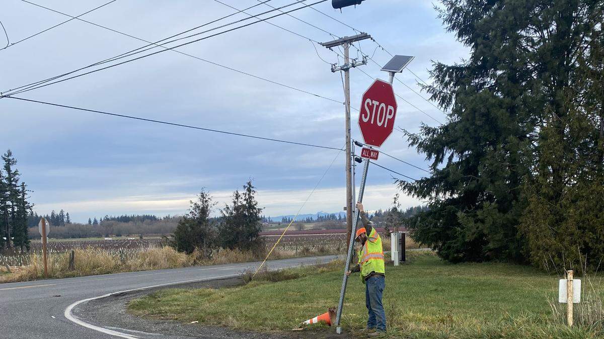 A worker with the Whatcom County Public Works Department’s Maintenance and Operations Division sets a stop sign at the corner of South Pass and Goodwin roads east of Everson on Thursday. The troubled intersection now has a four-way stop.
