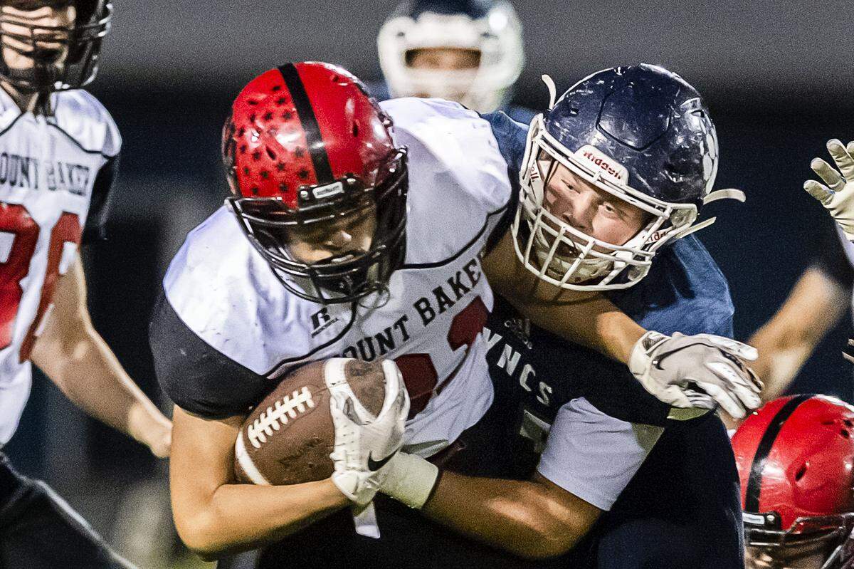 Mount Baker running back Jason Lee (31), left, gets pulled down by Lynden Christian linebacker Dylan Kaemingk (55) after a short gain during the first quarter on Friday evening Oct. 12, 2018, at Lynden Christian High School.