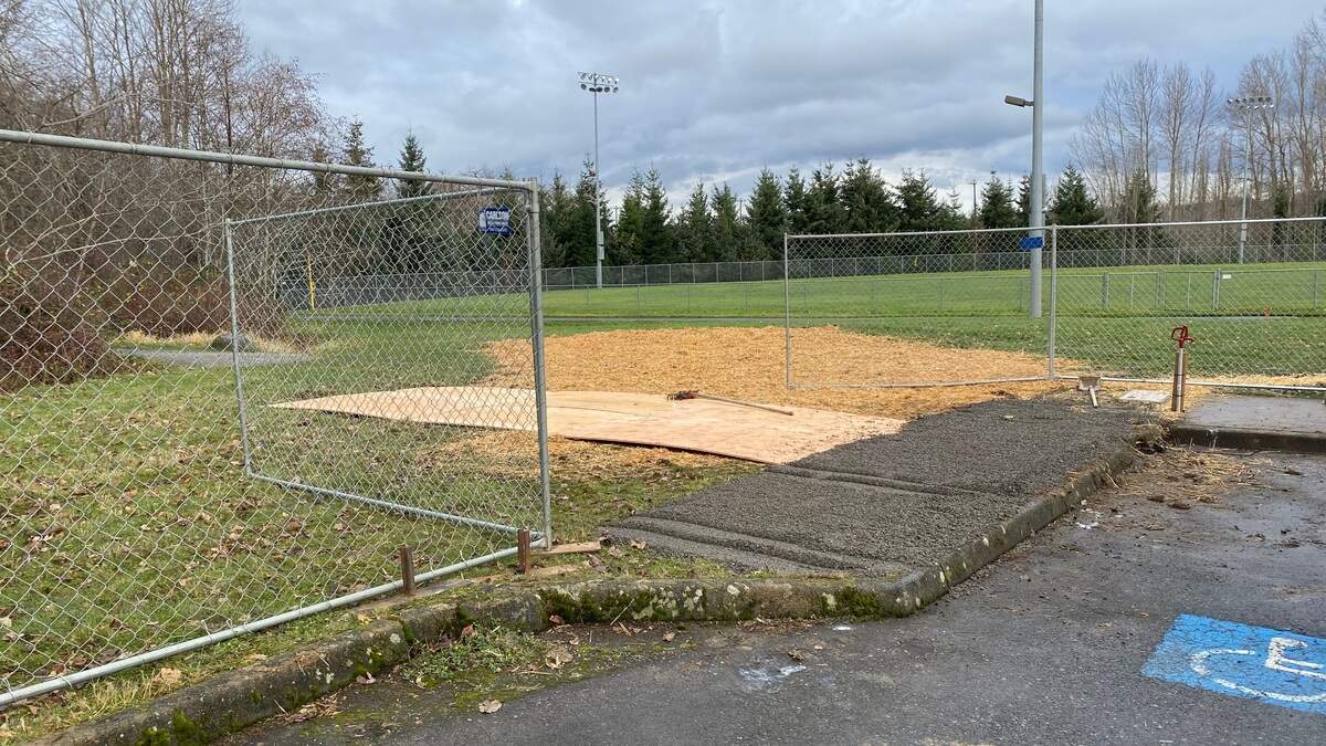 Straw is placed as a base for a new, temporary encampment for people who are without housing on Friday, Dec. 11, at Geri Fields in Bellingham.