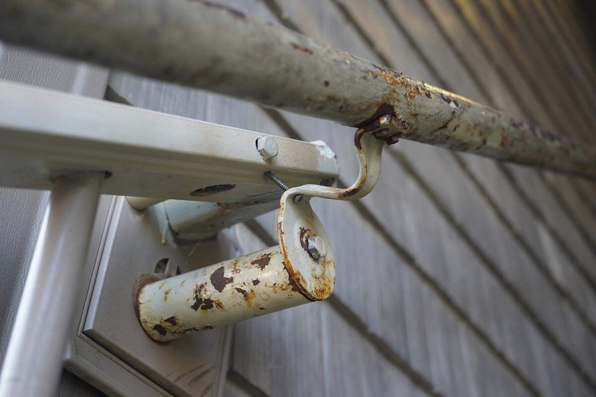 An unstable railing is rusted and held up by a screw at the Meadow Wood Townhomes on Sept. 22, in Bellingham, Washington.