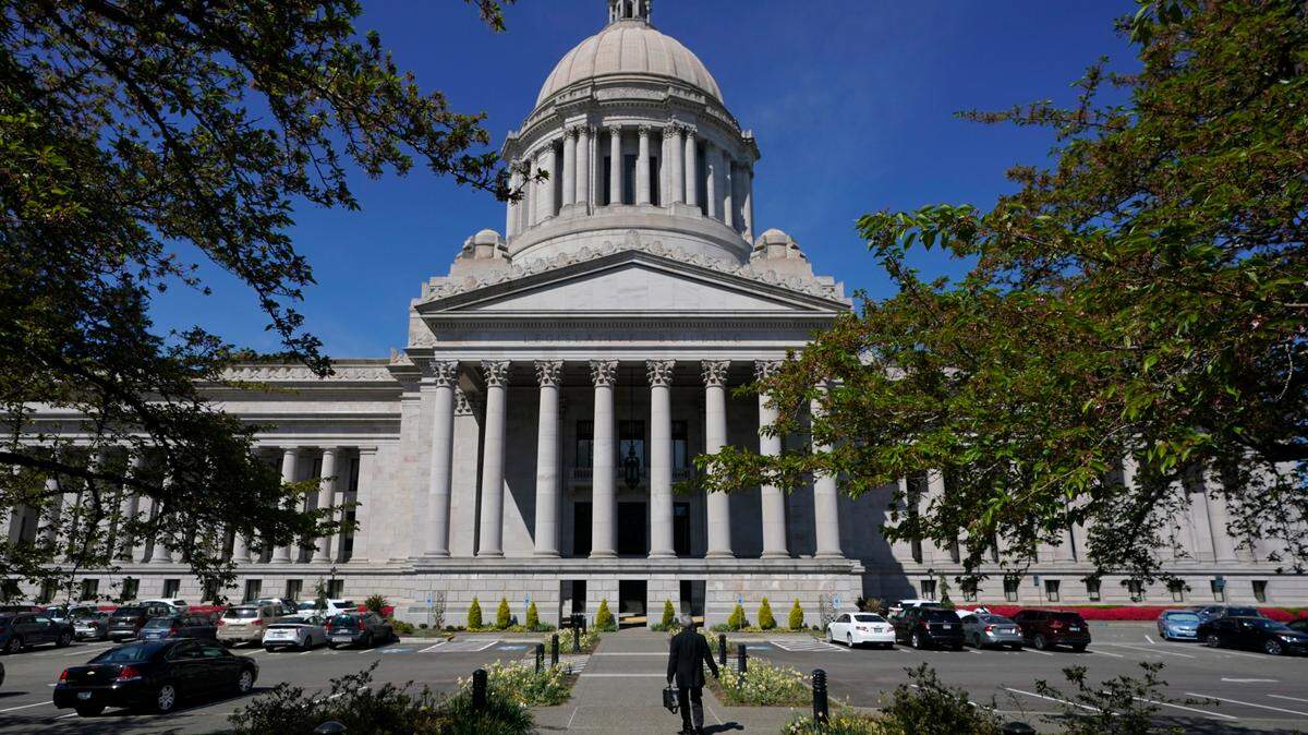 A person walks near the Legislative Building, Wednesday, April 21, 2021, at the Capitol in Olympia, Wash.