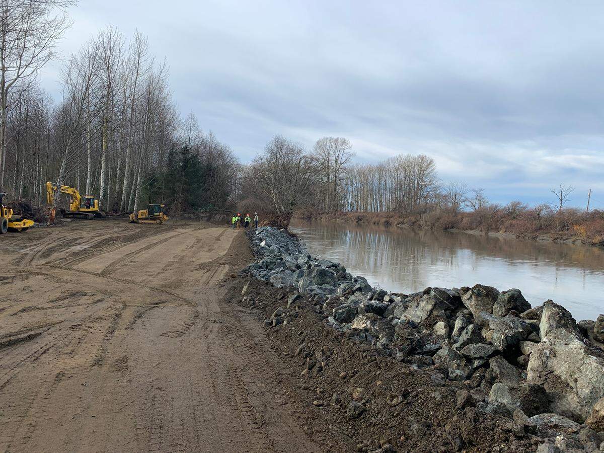U.S. Army Corps of Engineers contractors repair a levee Monday, Jan. 2, along the Nooksack River just south of the Slater Road bridge south of Ferndale. Pooled water was filled in and the levee wall repaired.