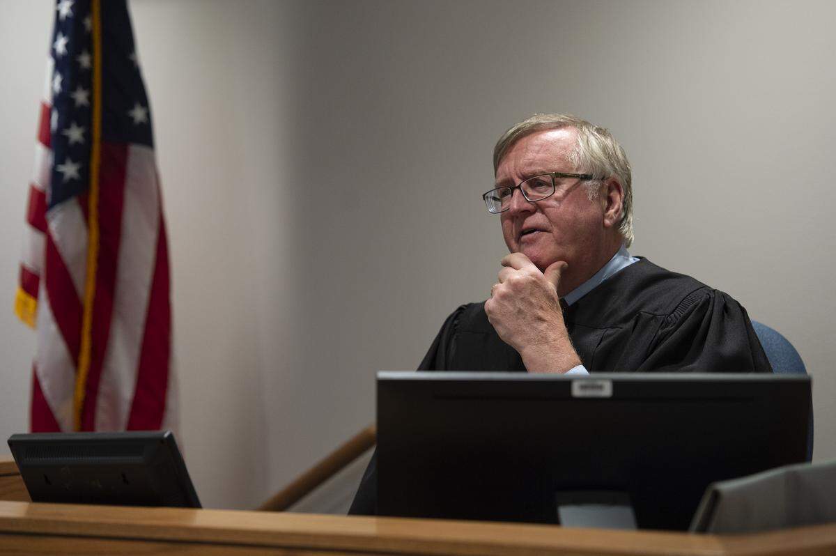 Court Commisioner David Thorn speaks to Whatcom COunty Prosecuting Attorney Eric Richey during during Ryan Nolan MacFarlane’s first appearance at the Whatcom County Superior Court in Bellingham on Monday. MacFarlane was accused of making a bomb threat Sunday at the Regal Cinemas movie theater.