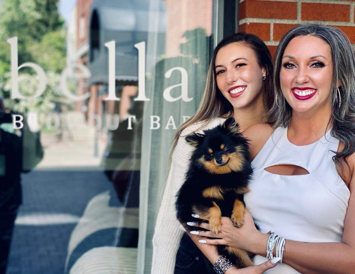 Brooke Shoemaker, Bella blowout bar owner Heather Gauf and dog Berlin outside the Fairhaven business. The salon is offering dry styling, hair washing and styling, up-dos, bridal hair, braiding and will also do children’s hair.