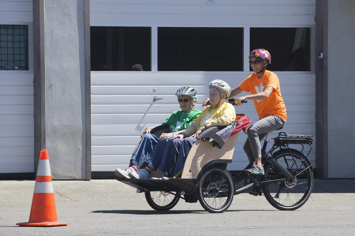 Mary Latta, right, takes Jane Morris, left, and Mary Elizabeth Simpson for a ride on a pedicab in the Fanatik Bike Co. parking lot on Tuesday in Bellingham.