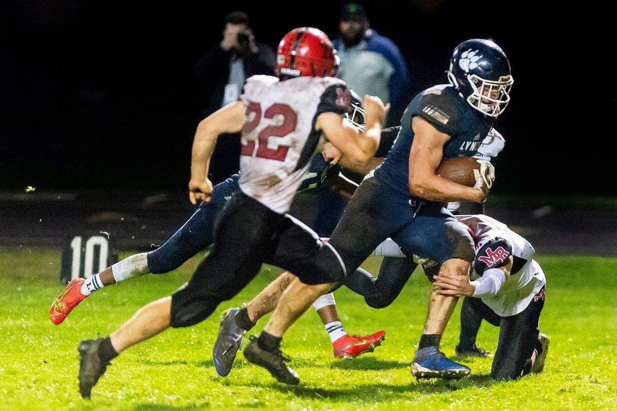Mount Baker linebacker Jesse Sande (22), left, moves in as teammate Landon Smith (2), on the ground, attempts to stop Lynden Christian tight end Kade Eldridge (44) as he runs 21 yards for a touchdown during the third quarter in their Division 1A conference game on Oct. 22 at Lynden Christian High School.