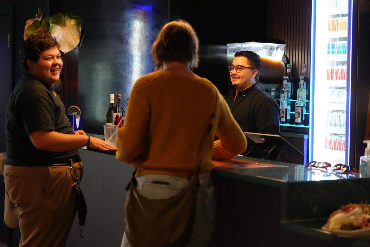 Guests mingle at the counter inside -HUT-, a newly opened nightclub and rentable venue.
