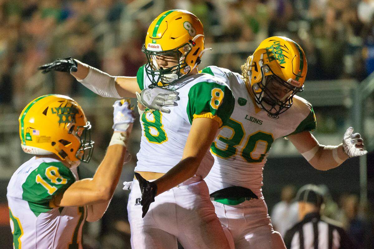 Lynden teammates Colin Anker (18), left, and Isaiah Oudman (30) celebrate with Isaiah Stanley (8) after scoring a touchdown in the fourth quarter on Friday evening Sept. 2, at Blaine High School. Lynden defeated Ferndale 24 to 7 in their season opener.