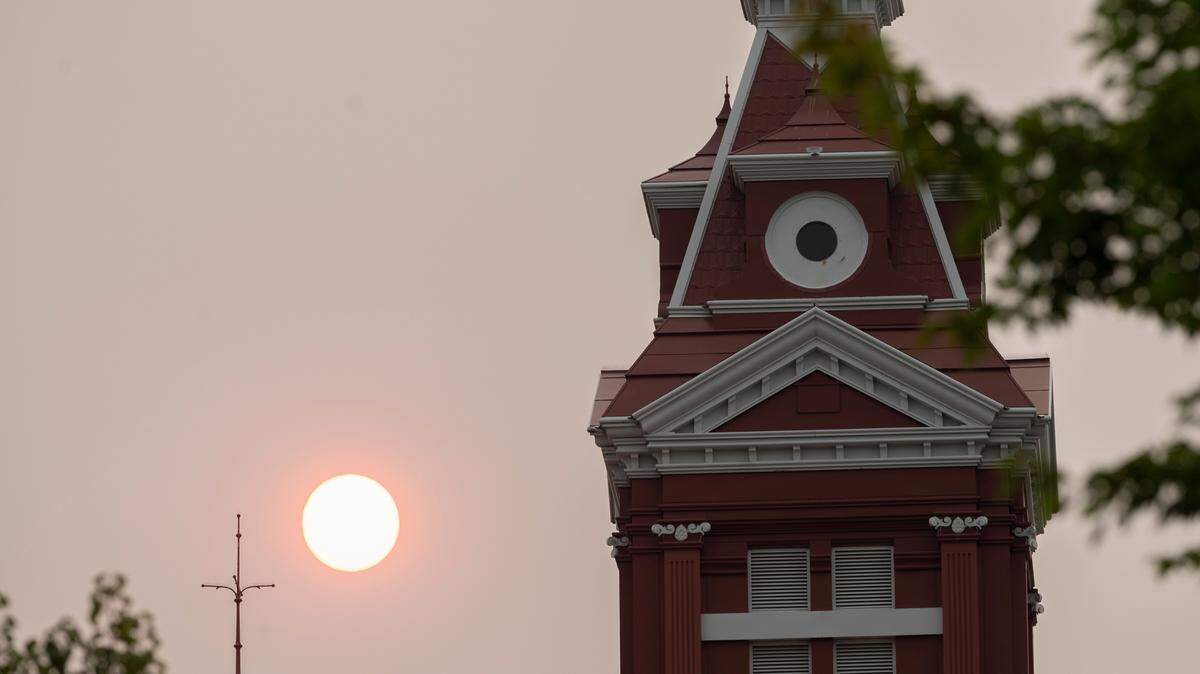 Wildfire smoke turns the sun into orange fireball as it sets past the Old City Hall in Bellingham in August 2021.