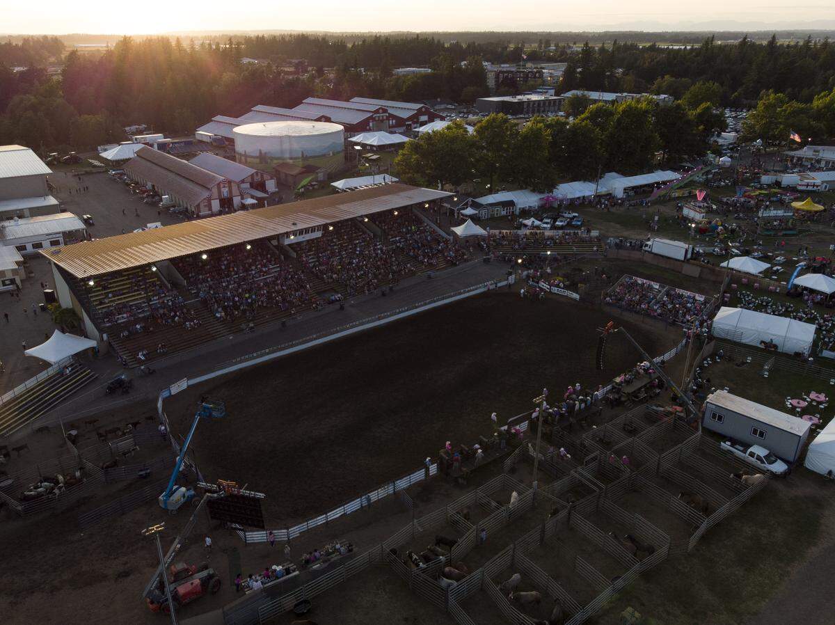 The sun sets over the rodeo at The Northwest Washington Fair in Lynden Tuesday night.