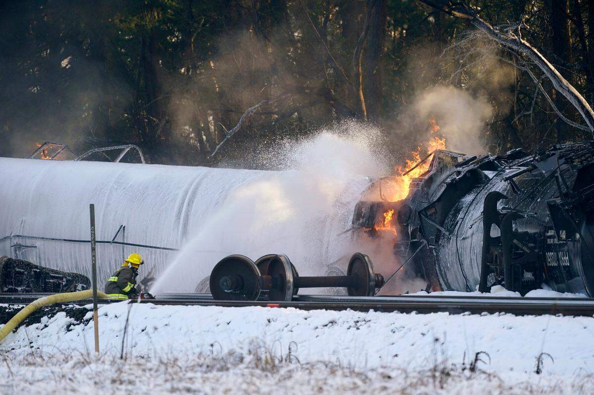 A firefighter sprays foam on a burning, derailed train car Tuesday, Dec. 22, 2020, in Custer. State Sen. Doug Ericksen is calling for the Legislature to hold hearings on the December 2020 derailment and fire of a BNSF oil train in Custer.