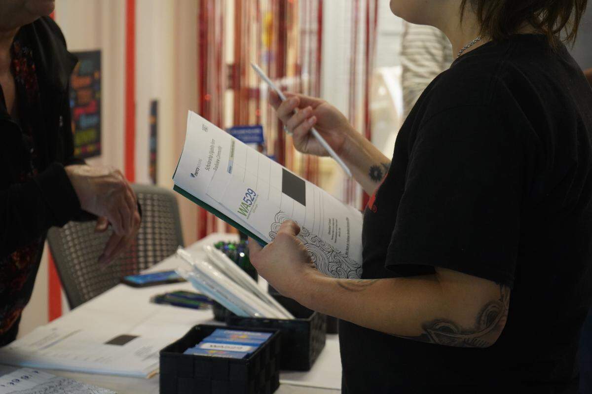 A parent is given information about the Washington College Savings Plan at a back-to-school event at the Trailview family apartments on Thursday, Aug. 24, in Bellingham, Wash.