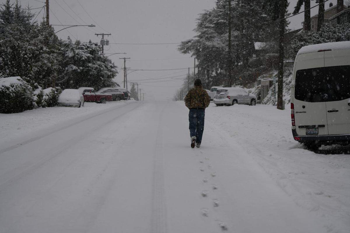 A person leaves footprints in the snow on N State Street while taking a morning walk on January 17, 2024, in Bellingham, Wash.