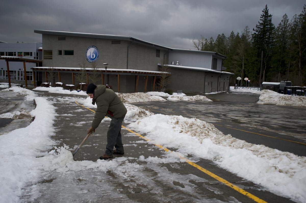 Custodian David Wagner shovels snow at Wade King Elementary School in Bellingham, Washington, on Thursday, Jan. 16. 2020.  Schools across Whatcom County were closed in the aftermath of a storm that left 4 to 7 inches of snow on the ground.