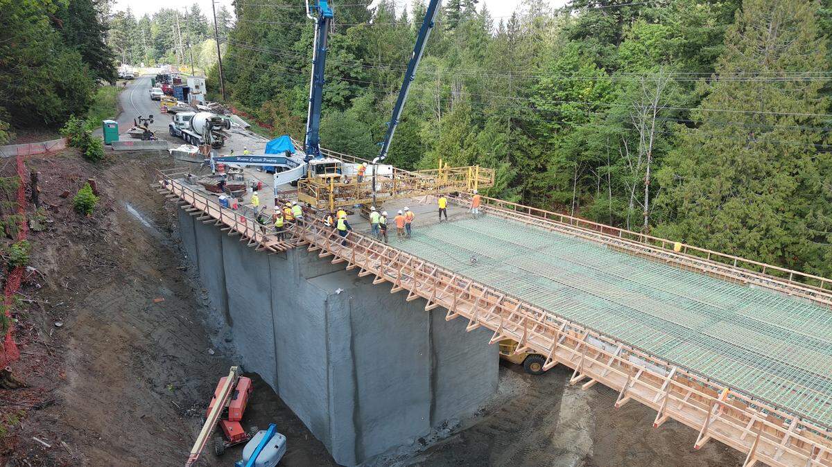 Construction workers pour concrete on the new bridge on the Mount Baker Highway in an undated photo from summer 2023.