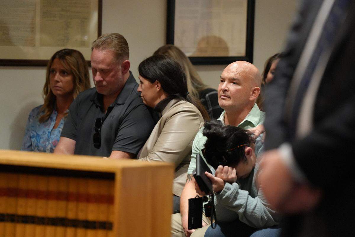 Now retired Whatcom County Sheriff’s Office Deputies Ryan Rathbun (right) and Jason Thompson, alongside their wives, react to the jury’s verdict in the Joel Young attempted murder trial on Sept.19, 2024. Young was found guilty of two counts of attempted second-degree murder.