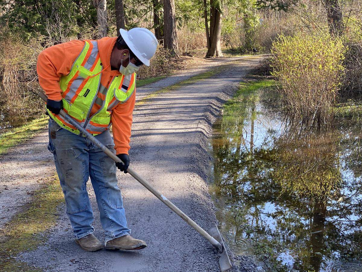 A construction worker repairs a driveway adjacent to Aldrich Road, keeping water from flowing onto a private property. ​​Bellingham announced Friday, April 10, that work on city capital construction projects that met certain exceptions in Washington Gov. Jay Inslee’s “Stay Home, Stay Healthy” order would resume next week.