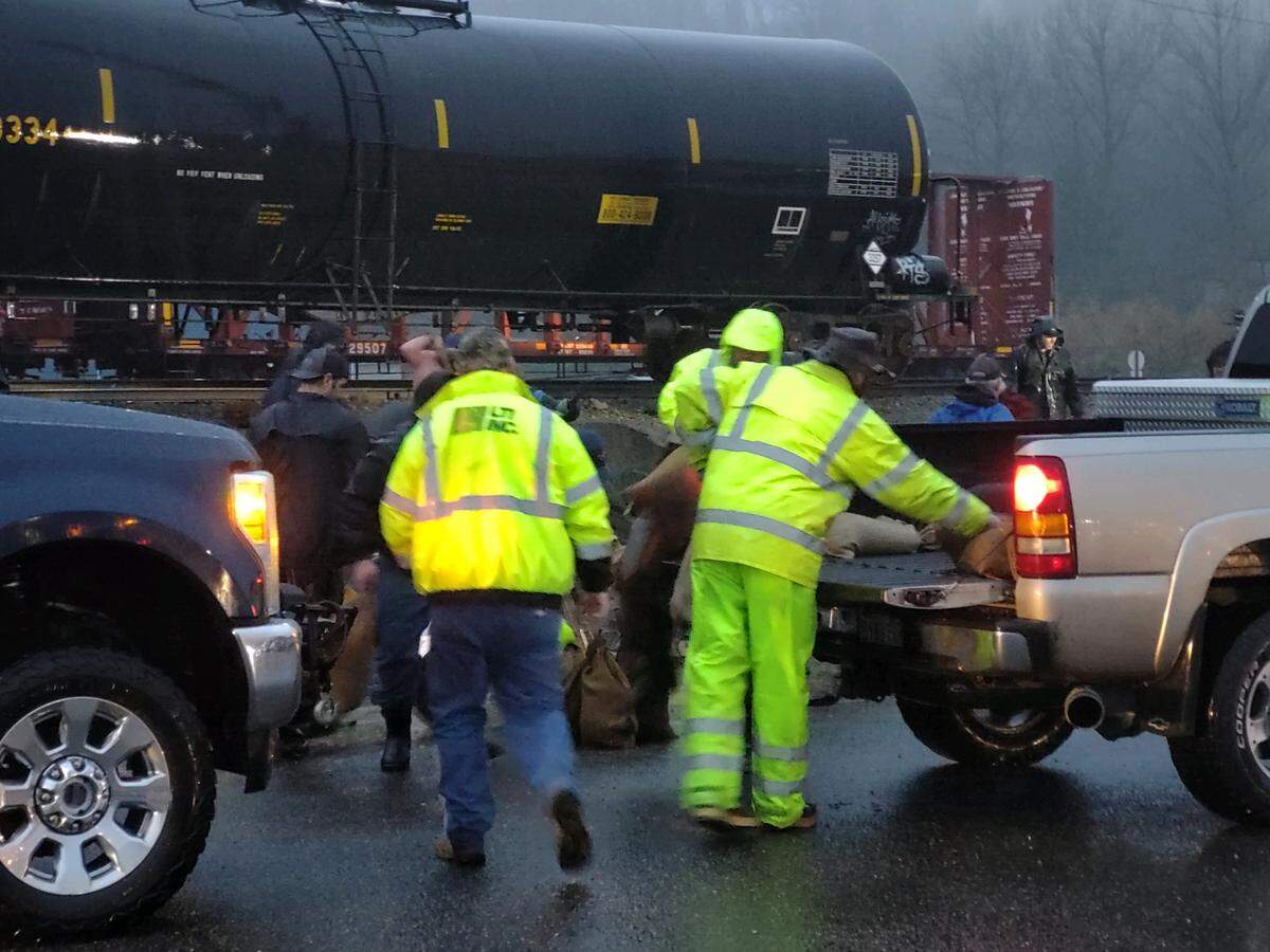 Volunteers load sandbags into trucks in Sumas on Sunday, Nov. 15. As residents spent much of Sunday preparing for the flood, the city was inundated with rainwater as well as flooding from nearby rivers and creeks, cutting off the community from the rest of Whatcom County.