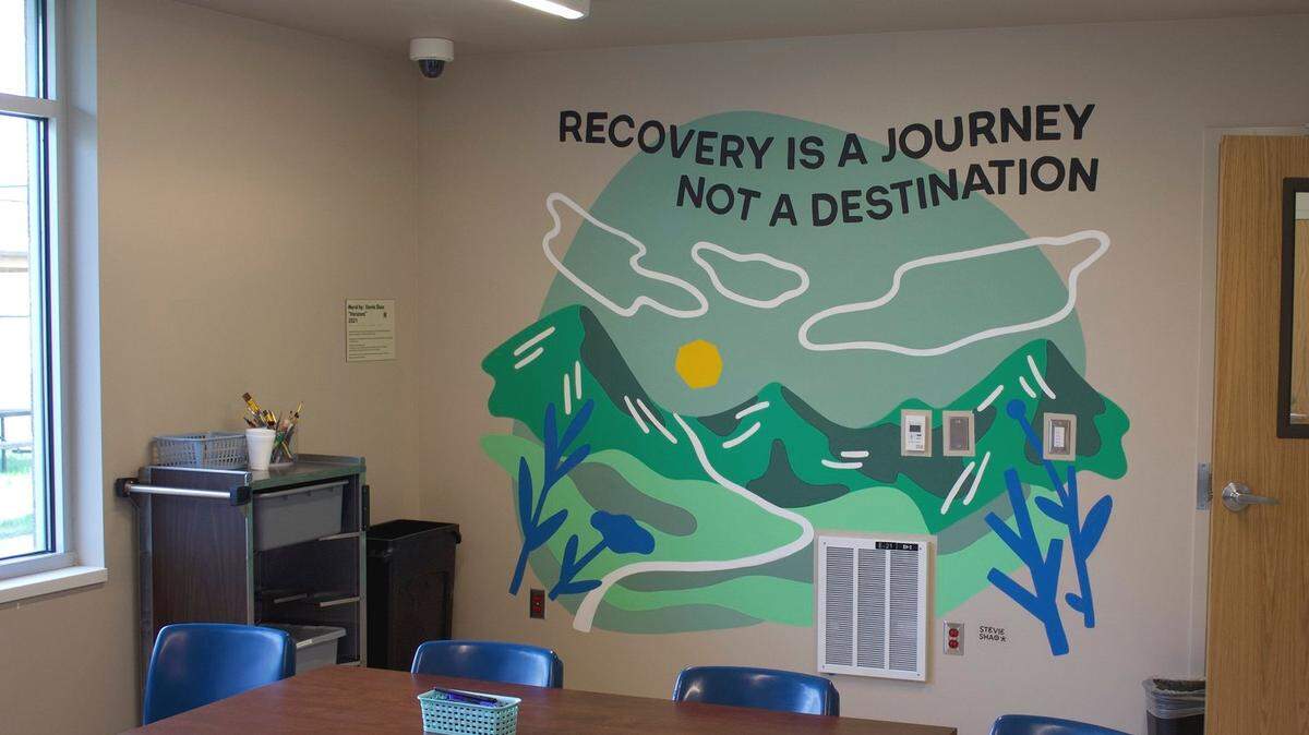 A mural inside the Whatcom Triage Center in Bellingham. depicts trees and a mountainscape.