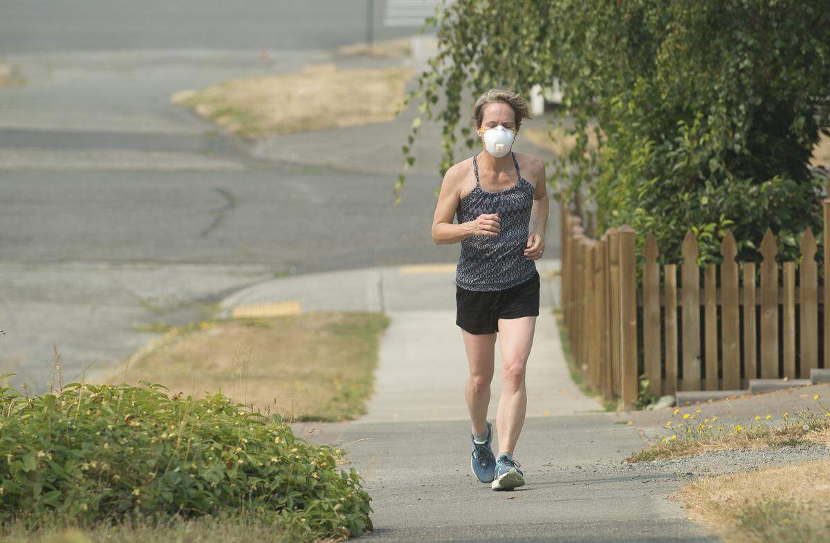 Rachel May wears a mask while jogging to protect her lungs from wildfire smoke on Tuesday in Bellingham.