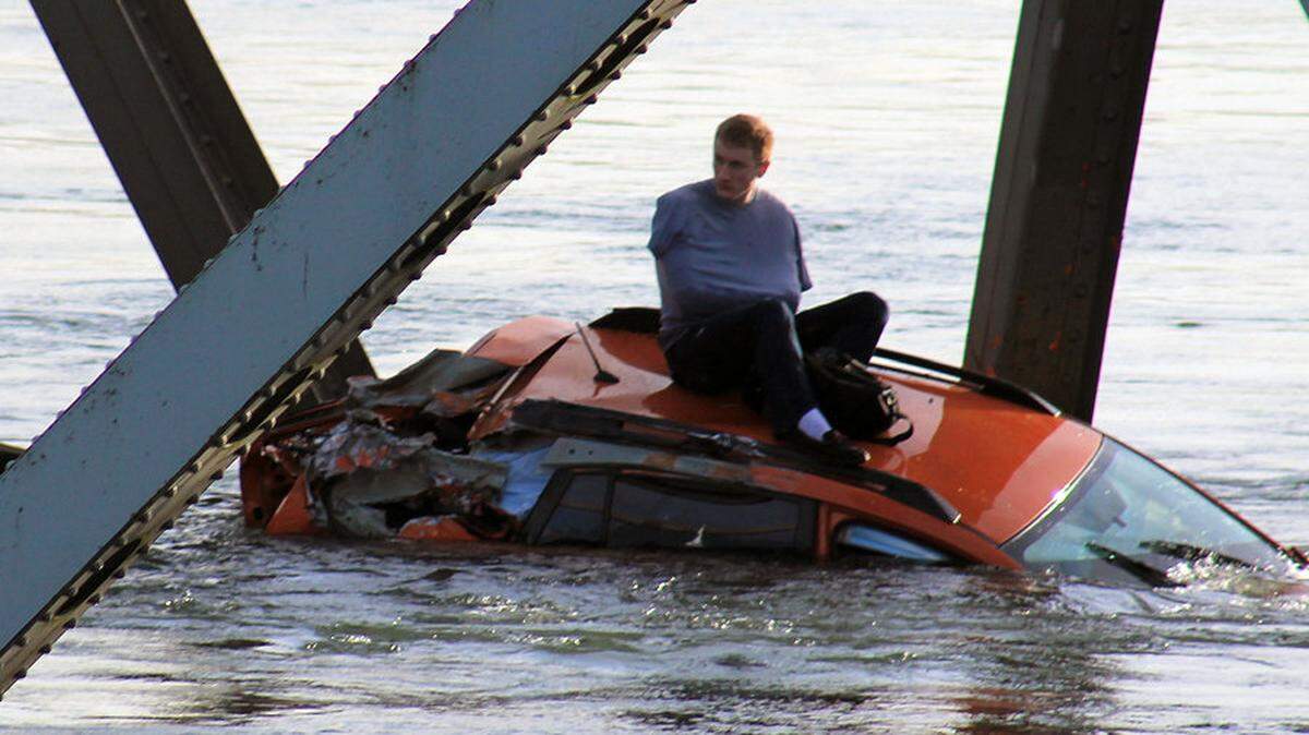 Bryce Kenning of Mount Vernon, who plays hockey with the Bellingham Blazers team, waits on his 2013 Subaru Crosstrek in the Skagit River Thursday May 23, 2013. The Interstate 5 bridge over the Skagit river collapsed north of Seattle Thursday evening, dumping two vehicles into the water and sparking a rescue effort by boats and divers as three injured people were pulled from the chilly waterway.