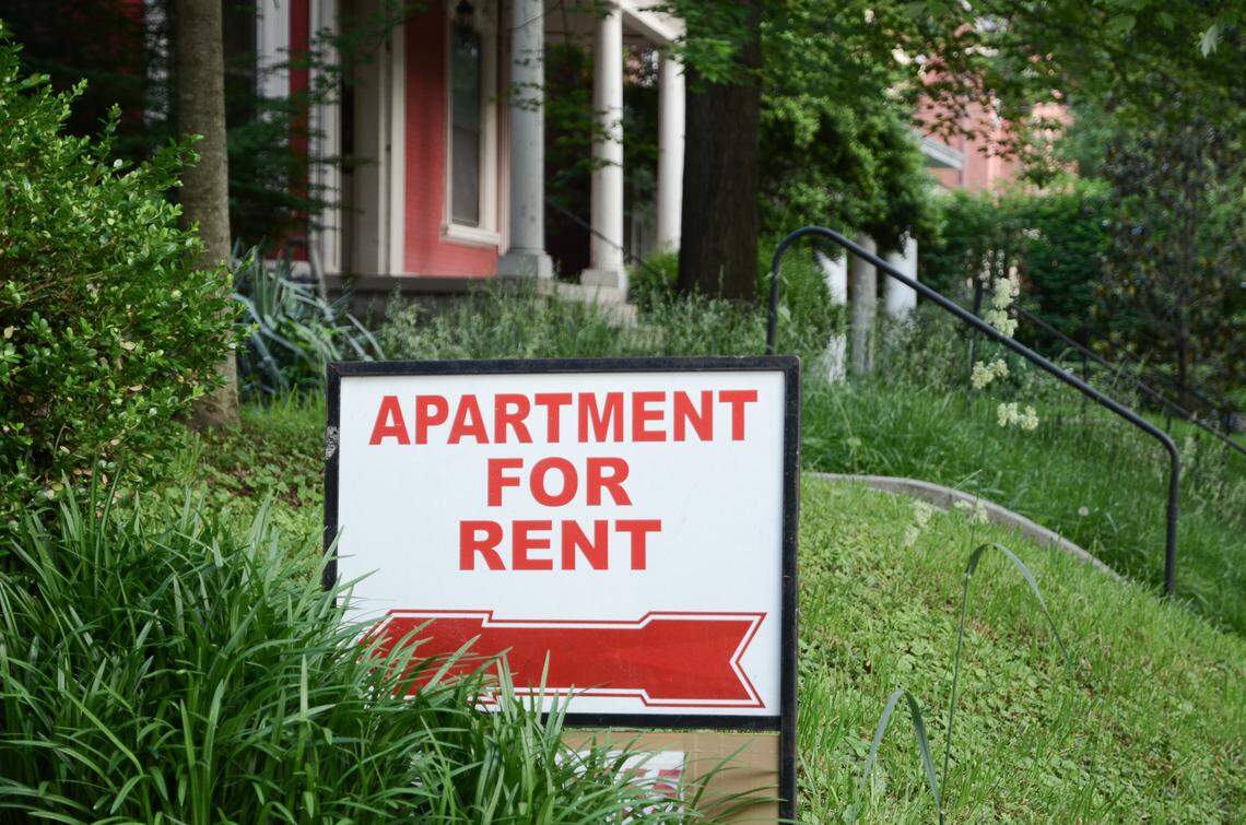 Apartment for rent sign displayed on residential street.